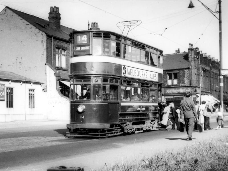 Passengers alighting from tram no.114 at a stop on Stanningley Road. The Station Garage is on the left. To the right of the tram is Bramley Home Bakeries at the junction with Hough Lane. Pictured in August 1952.