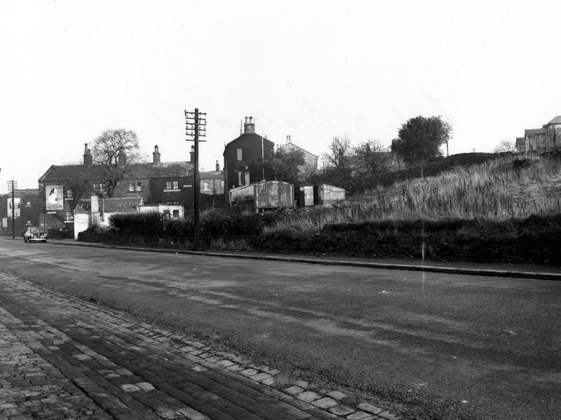 Leeds and Bradford Road. Whitecote Place is in the background. Old gas streetlight on left. Dry stone wall, greenhouse, shed, fish and chip shop. Pictured in November 1955.