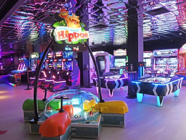A first look inside reveals a vibrant, high-energy entertainment playground packed with premium industrial-chic décor and neon lighting.