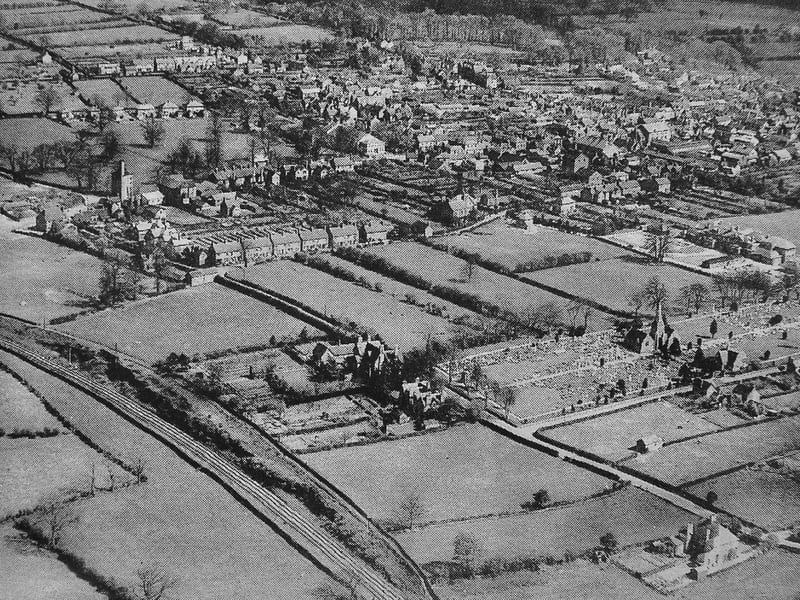 A striking aerial view of Market Drayton showing the town in an earlier era, with open land still surrounding much of the built-up area.