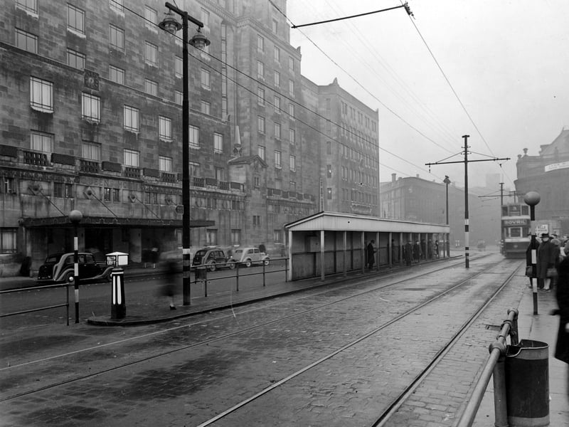 Leeds City Tramways Shelter outside the Queens Hotel on a grey December day. The photograph looks towards Wellington Street and the Majestic Cinema past the News Theatre and City Station. Pictured in December 1946.
