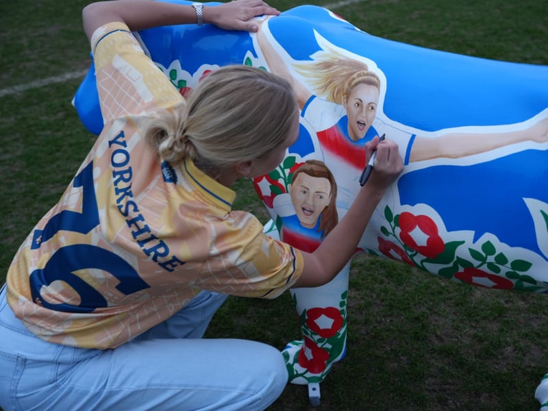 England Women's Footballer and Lioness Esme Morgan signs a lion.