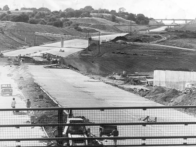 Work at the Hollinswood end of the M54 motorway bypass in July 1975, with nearly six miles of surfacing completed from Cluddley towards Wellington, and bridges including Dawley to Priorslee Road, Queenswood footbridge, and Overdale to Red Lake visible in the background.