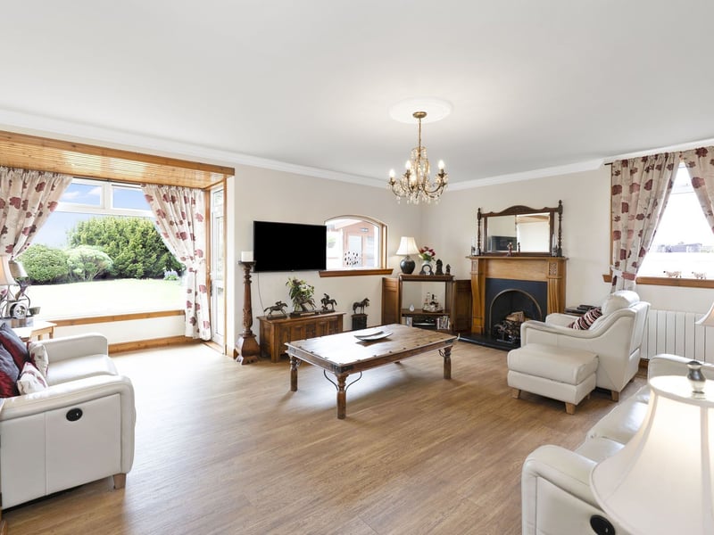 Expanding over 29 square metres, the dual-aspect living room effortlessly balances space and style, its neutral palette beautifully contrasted by the wood finishes. It enjoys feature glazing for added character and a handsome open fireplace which forms another eye-catching focal point. The space also provides direct access to the garden.