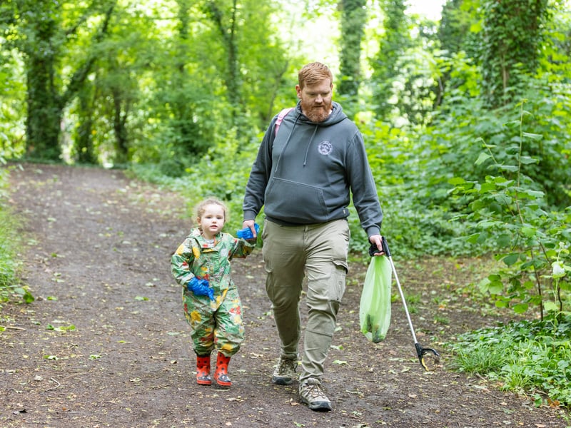 Matt and Isabella, three, picking rubbish together 