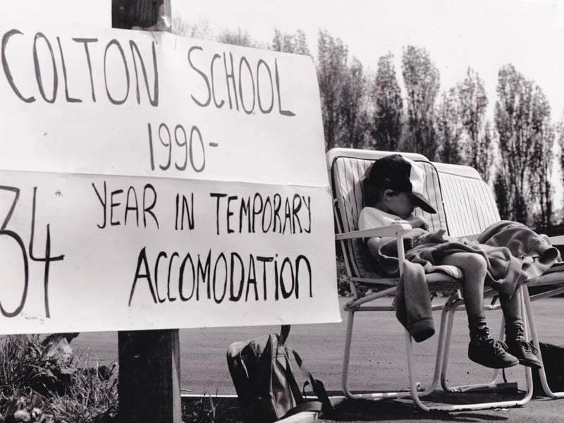 Lone vigil. A small boy sleeps through protests for a new school at the Colton Lane polling station in May 1990.
