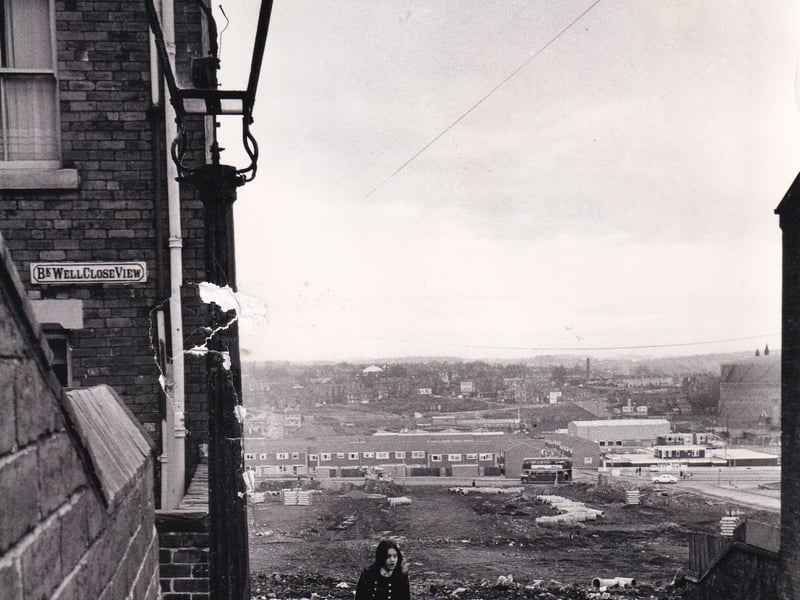 A young woman walks past Back Well Close View in February 1973 against a backdrop of demolition.
