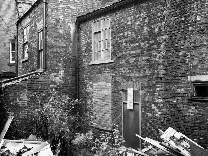 The rear of very old and derelict properties in Queen Square awaiting demolition in October 1974. On the left is number 64 Queen Square, and on the right, number 66. Immediately behind number 64 part of the Cobourg Tavern is visible and faintly in the background the College of Technology can just be seen.