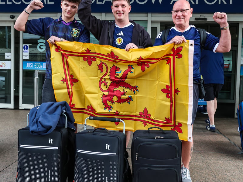 These Scotland fans display their flag at Glasgow Airport.