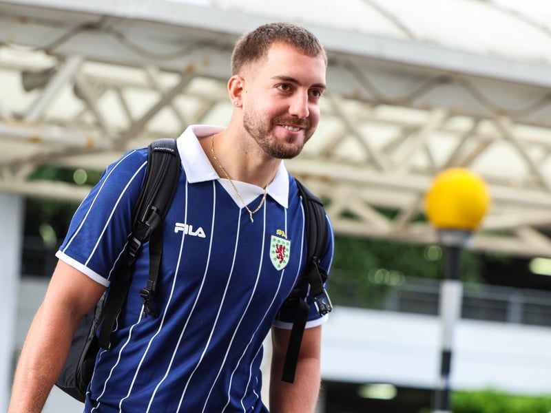 A Scotland fan dons a retro jersey as he heads to the departure lounge at Glasgow Airport.