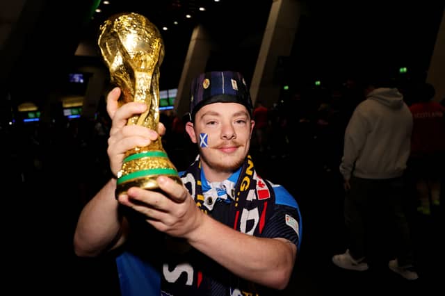 A Scotland fan with a replica World Cup trophy at the Hydro