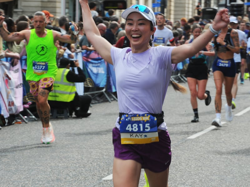 More runners celebrating finishing as they arrive on the Headrow in Leeds.