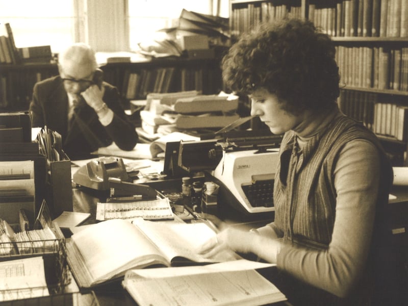 Library staff members at their desks in the admin and book services department of Leeds Central Library. The gentleman in the background is Mr Baxendale