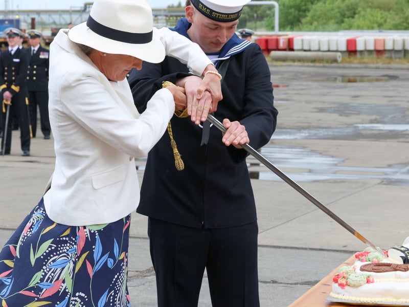 Commanding Officer's wife with AB Pollard from the ship's company cutting the cake during the commissioning ceremony.