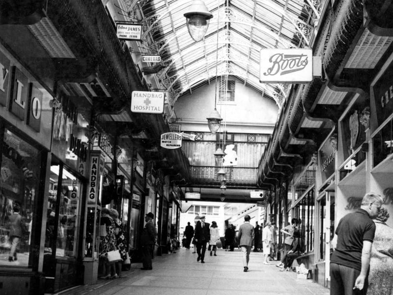Inside Queen's Arcade looking up from Boots towards Lands Lane. Shops visible include Boots, Handbag Hospital and Stylo.
