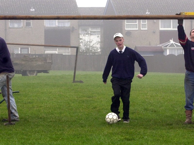 Leeds City Council were put up a goal post on grass land off Stanks Drive in November 2002. Pictured on Tuesday 19 November 2002 Pictured, from left, are contractors Nick Crabbe, left, and Sean Munson with John Smeaton High School pupil Richard Lee.