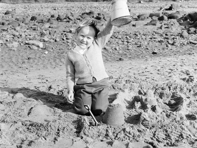 A little girl shows off her sandcastle on Portobello Beach in July 1965.