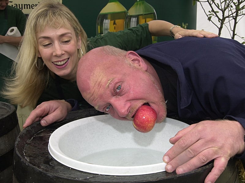 Fiona Benwell, promotions assistant with Gaymers, urges on Rev. Mike Benwell, vicar of St. Luke's at Swarcliffe, at the apple bobbin championships held at Tesco Extra in Seacroft in August 2001.