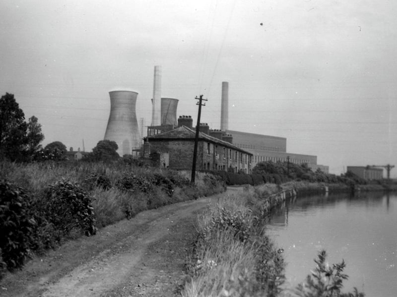 The cottages at Dandy Row pictured circa 1950s. Dandy Row housed workers at Thwaite Mills, and was effectively an island, surrounded by the River Aire, the Aire & Calder Navigation, and the mill stream. They were demolished in 1968. Skelton Grange 'A' power station is visible behind the cottages, with two cooling towers at this time.