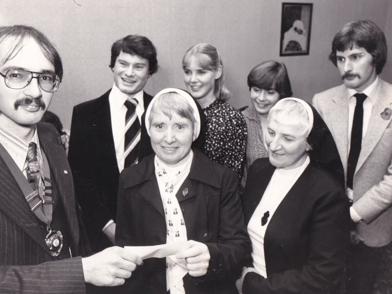 Graham Dixon, left, president of Rotaract Club of Leeds is pictured presenting a £700 cheque to Sister Charlotte McNeill, centre, bursar of St Gemma's Hospice in November 1980. The club hoped to raise a total of £1,000 through sponsored events.
