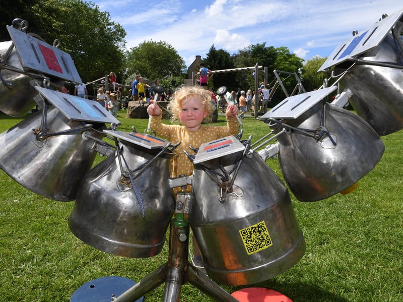 Two-year-old Thea pictured playing one of the instruments in the Orchestra of Objects.