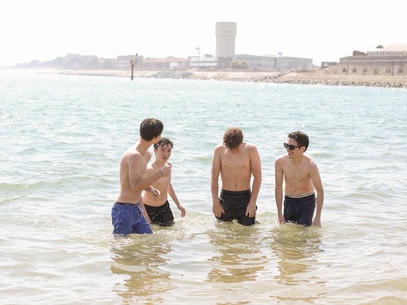 A group of lads cooling off in the water.