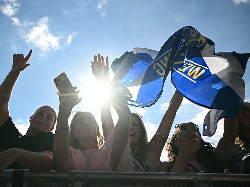 Festivalgoers watch main stage acts in the sunshine.