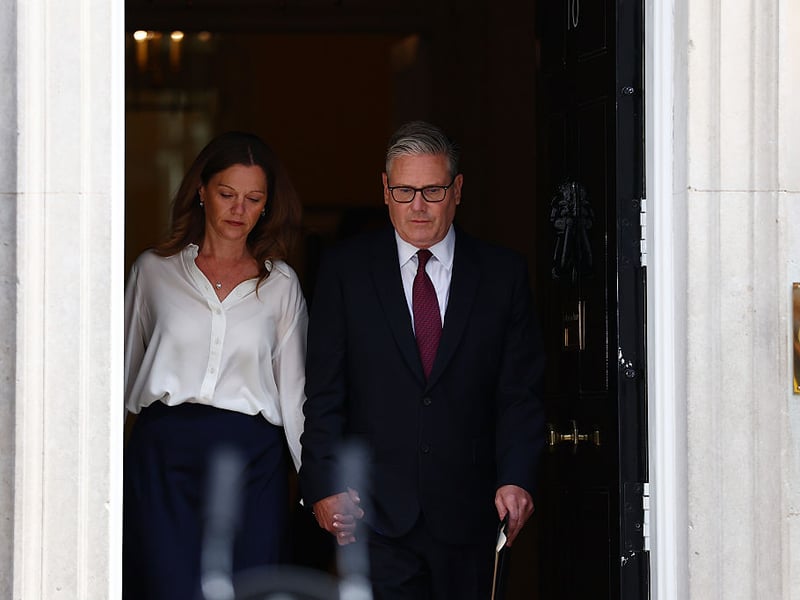 Prime Minister Keir Starmer and his wife, Victoria Starmer, walk out onto Downing Street.