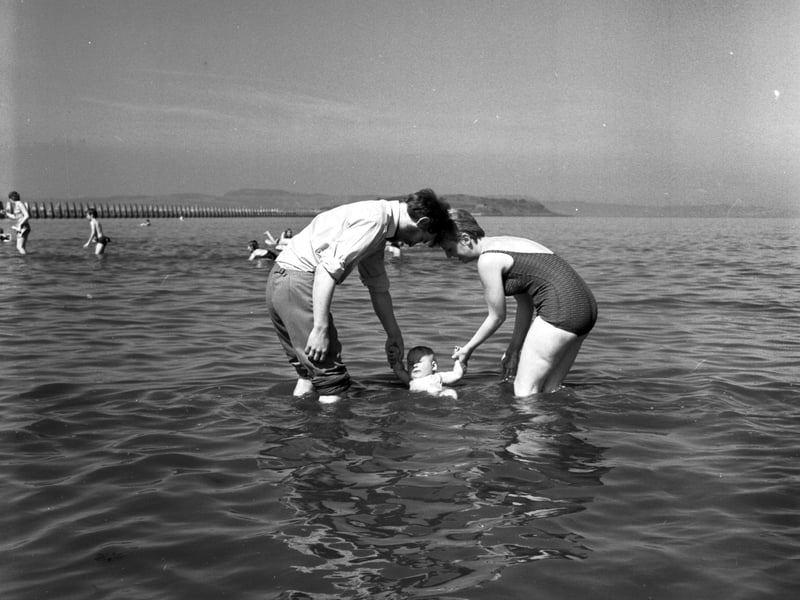 Mr and Mrs Bain dip their baby daughter into the water at Cramond in August 1970.
