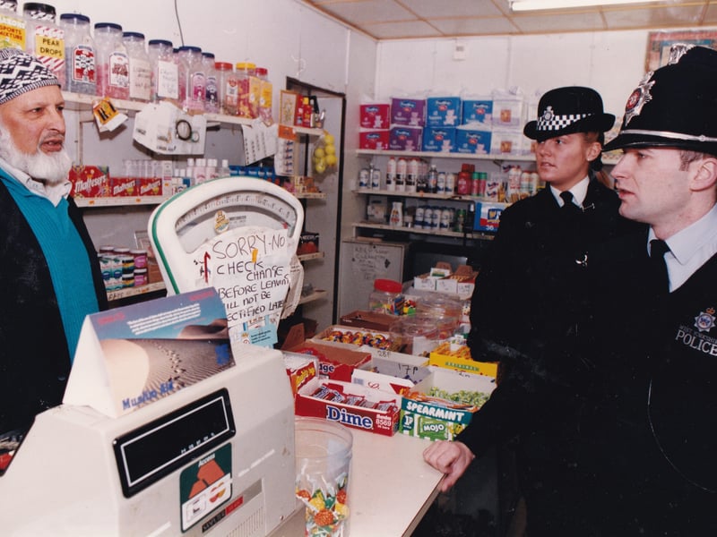 Police chat to staff at an off licence on Chapeltown Road in March 1994.