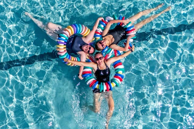 Susie MacDonald (left), Charlotte Reader (right) and Emma Ledger (centre) cool off from the hot weather at Cumnock open-air swimming pool in East Ayrshire.