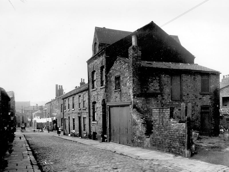  Looking down Back Barrack Street in the direction of Sheepscar Street. A woman is outside number 21, then moving right are 23 and 25. On the right is an area of waste ground, this is access into Victoria Row. Pictured in August 1958.