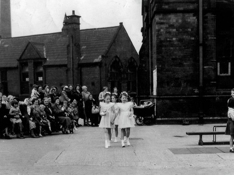 Taken in the playground of Sheepscar Council School, parents and carers have gathered to watch the pupils take part in May Day celebrations.