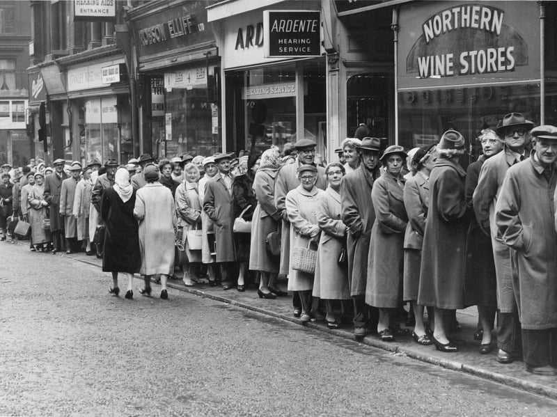 People queue in the autumn rain on Albion Street, Leeds, in October 1959 to book their summer holiday for next year