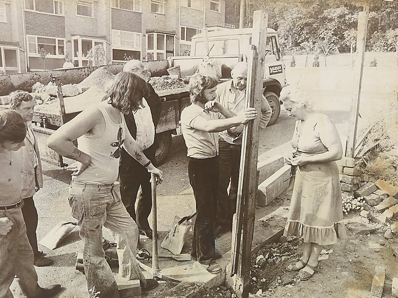 Actress Pat Stone disputes the removal of a boundary post as Dudley Council workmen and police stand by outside her home in Mount Pleasant, Kingswinford, in August 1976. The dispute flared up after workmen arrived to remove fence posts and replace sloped kerbstones with straight ones in the cul-de-sac backing onto her garden, prompting Mrs Stone to lodge immediate complaints over the legality of their actions. While she insisted she had personally paid for the sloped stones to be installed, the local authority stated they were acting strictly within legal boundaries at the request of a Stourbridge building firm that owned the strip of land. Did you live around Mount Pleasant or follow the dramatic neighbourhood kerb dispute in Kingswinford during the hot summer of 1976?