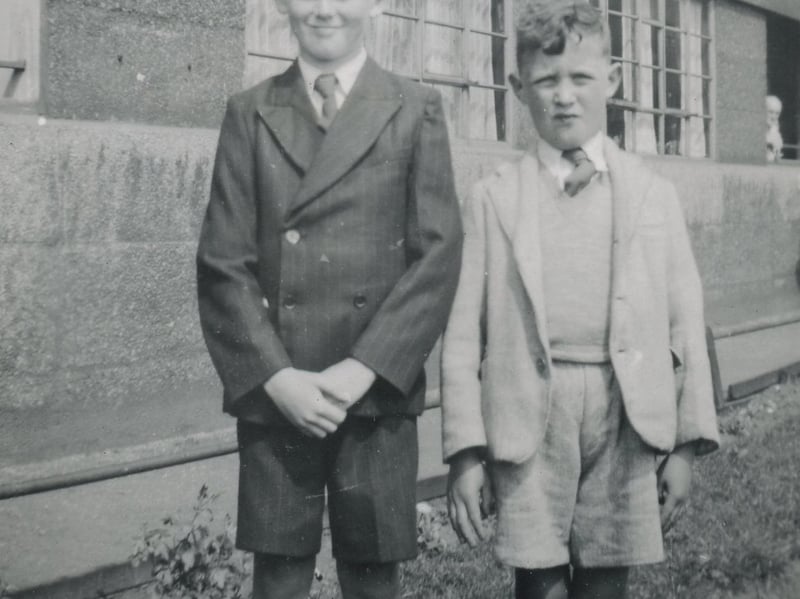 Two young boys in smart clothes pose for a photo outside Quarry Hill Flats.  Pictured circa 1950s.