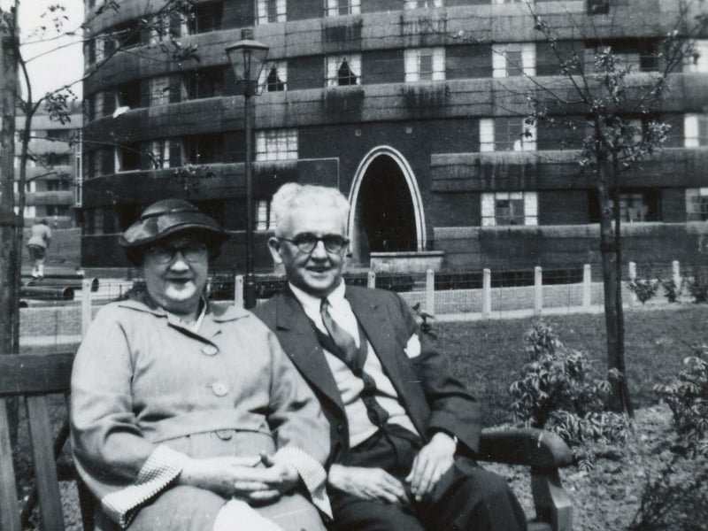 A couple pose for a photo on a bench in the gardens outside Quarry Hill Flats circa 1950s.