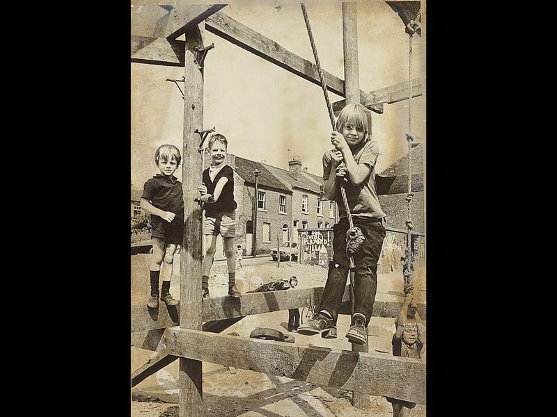 The ultimate 1970s playground adventure! Youngsters including Michael Greenfield take over the wooden climbing frames and rope swings at Caldmore Adventure Playground in Walsall during a sunny August in 1975. With timber beams to scale and thick ropes to swing from, the bustling park provided endless summer excitement for local kids making the absolute most of their school holidays.