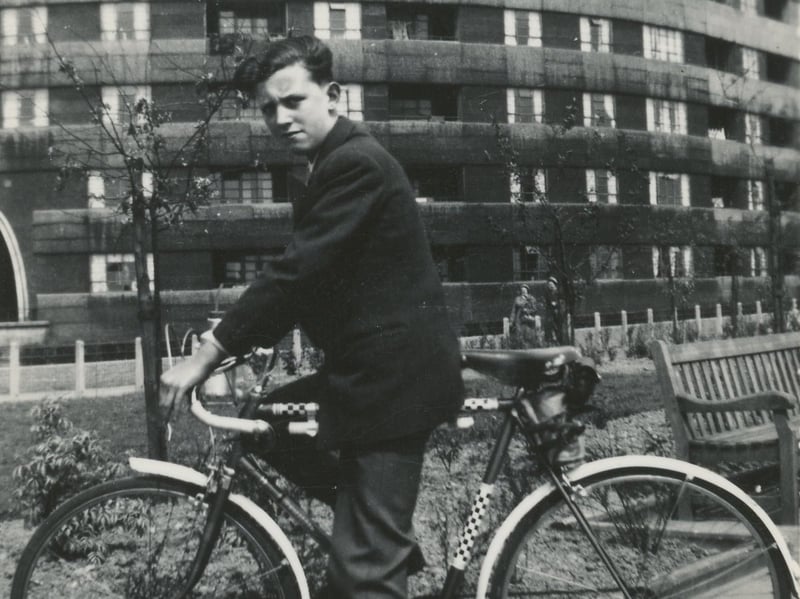 A boy poses for a photo on his bicycle in the gardens of Quarry Hill Flats.