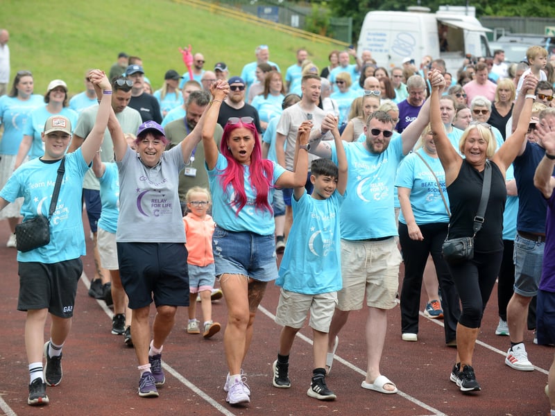 These participants put their hands in the air as they near the finish line.