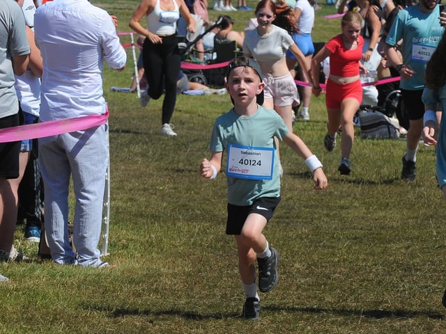 Little Sebastian Samuels crosses the finish line. 