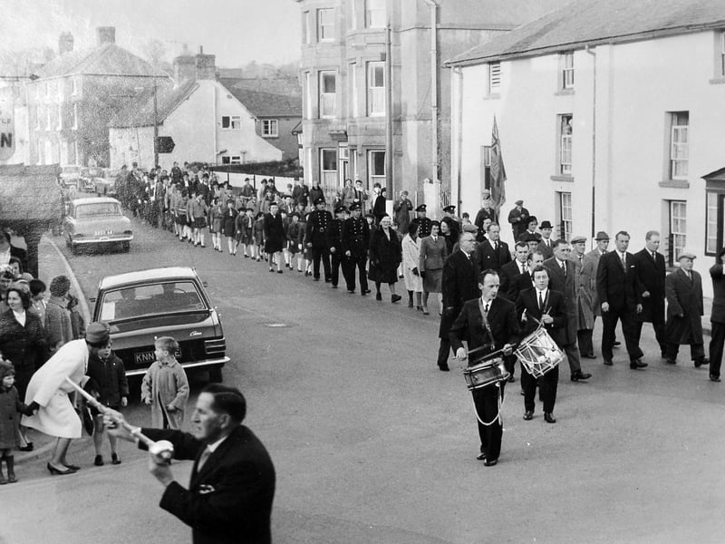 Led by drummers and local dignitaries, a civic parade winds through the streets of Bishop's Castle during a historic church procession in March 1967. The photograph by Ludlow photographer Peter Bartlett captures the final official church march by the Mayor and Corporation before the ancient borough council was merged with Clun Rural District Council the following month. Bystanders and children lined the road to watch the ceremonial parade, marking a major turning point in South Shropshire's local government history. Do you remember watching the final Mayor's parade in Bishop's Castle before the council amalgamation in April 1967?