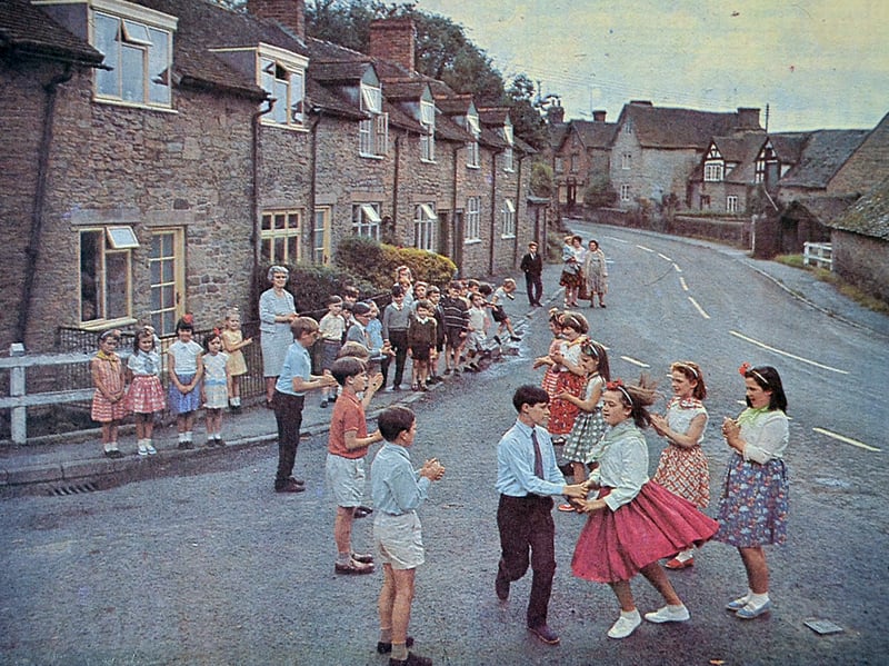 Bright dresses twirl against picturesque stone cottages as pupils practise traditional country dancing in the quiet Corvedale village of Munslow. Originally printed in full colour on the front page of the Shropshire Journal on 30 July 1965, the delightful scene captures local schoolchildren rehearsing for their annual open day. Trained under the watchful eyes of headmistress Mrs B Gregory and her assistant Mrs M Harris, the young dancers bring a wonderfully lively, idyllic slice of rural Shropshire life to the open air. Were you one of the young country dancers taking part in Munslow that summer, or do you remember the school open day performances from July 1965?
