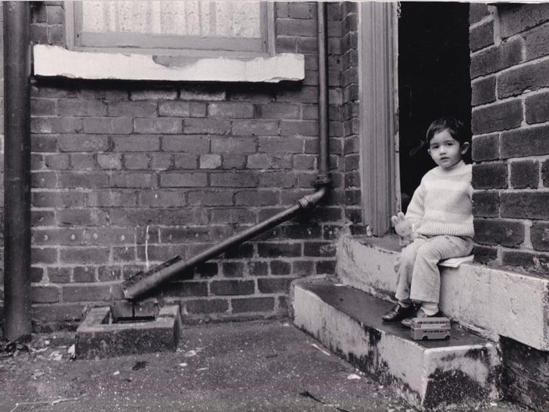 A toddler sits on the steps of his home on Lascelles Road in January 1988.