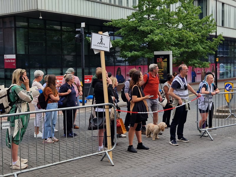 Pedestrians wait to cross the circuit at a safe crossing point manned by race officials at the Sheffield cycling grand prix. Photo: David Kessen, Iconic Media