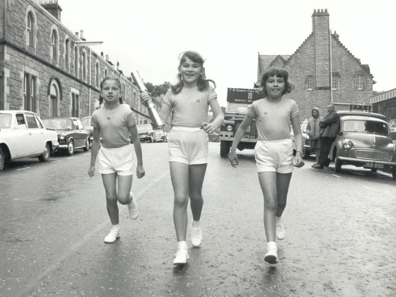 Children carry the Queen's Baton through the streets of Edinburgh.