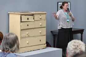 Dolores Lyne explaining the significance of a battered chest of drawers to her granduncle's life.