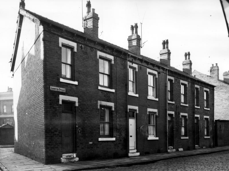 Andover Street from the corner with Northcote Road. Houses number from left to right 16 to 10. These are back-to-back brick terraced properties opening directly onto the pavement. In the background left is Andover Place. Pictured in November 1965.