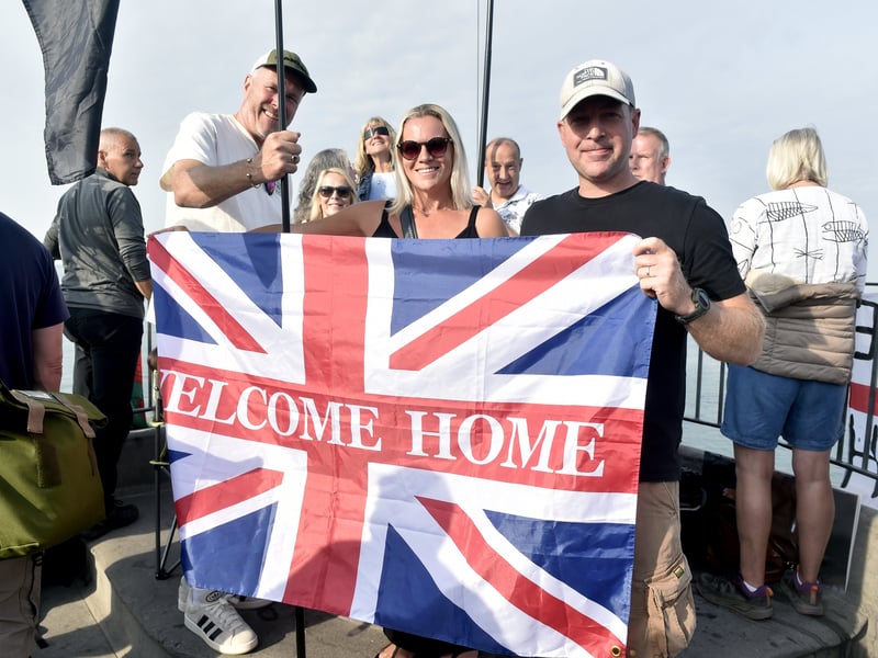 Pictured is: (middle and right) Donna Viv and Matthew Rogers, both excited to welcome home AB Lewis Hawkins (20) aboard HMS Prince of Wales. They travelled from Derbyshire.