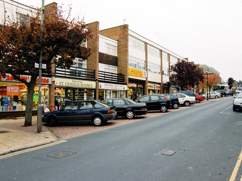 A parade of shops in Horsforth Town Street, which include a branch of Morrison's supermarket. Car parking is laid out in front of the shops and Town Street is one way since the relief road, Church Road, was constructed in 1971.